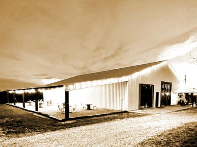 Large barn illuminated at night with an open side.