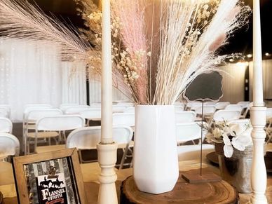 Elegant wedding decor with pampas grass and candles on a wooden table.