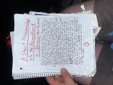 Handwritten notes titled 'A Short Phenomenology into the Recognition of a Demon' on lined paper.