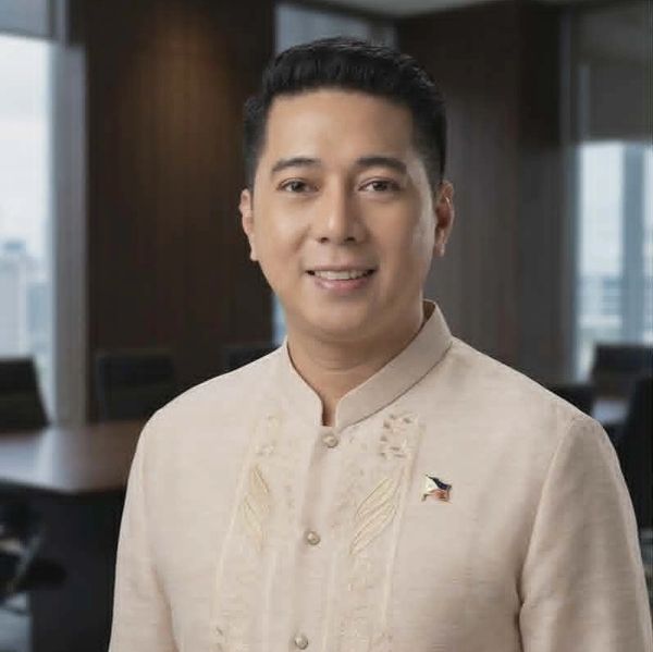 A man smiling in traditional Filipino Barong Tagalog indoors.