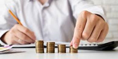 Person stacking coins in ascending order on a desk.
