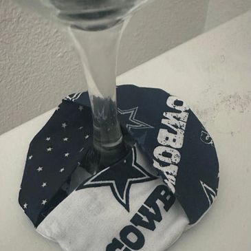 A Dallas Cowboys-themed coaster under a glass on a table.
