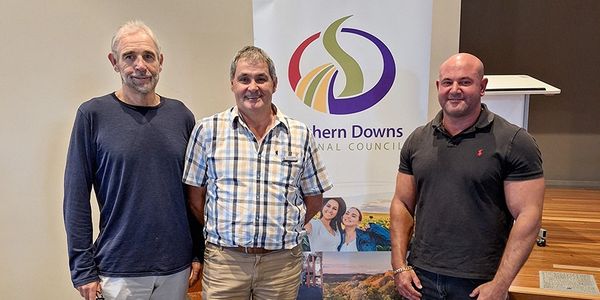 Three men stand together in front of a Southern Downs Regional Council banner.