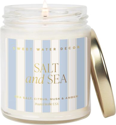 Lit Sweet Water Decor candle with sea salt scent.