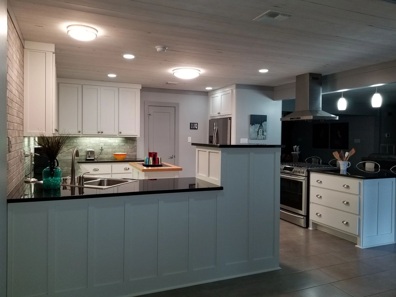 Kitchen granite counter tops, stainless  appliances, and wood white wash ceiling