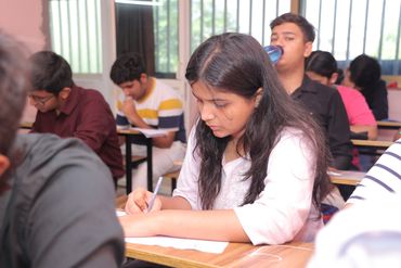Students focused on writing during an exam in a classroom.