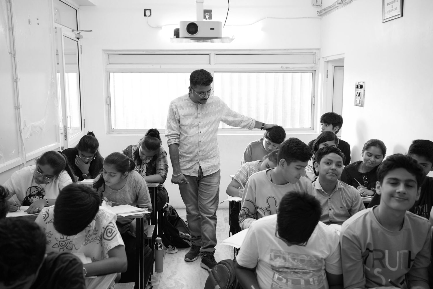 Teacher helping students in a classroom during a study session.