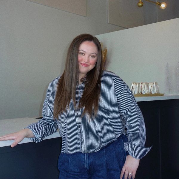 Woman smiling and leaning on a counter.