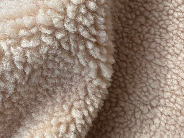 Close-up of soft, fluffy beige fleece fabric.