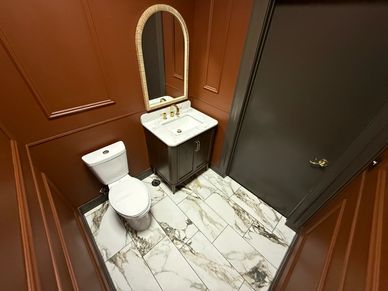 Small bathroom with toilet, sink, and mirror.