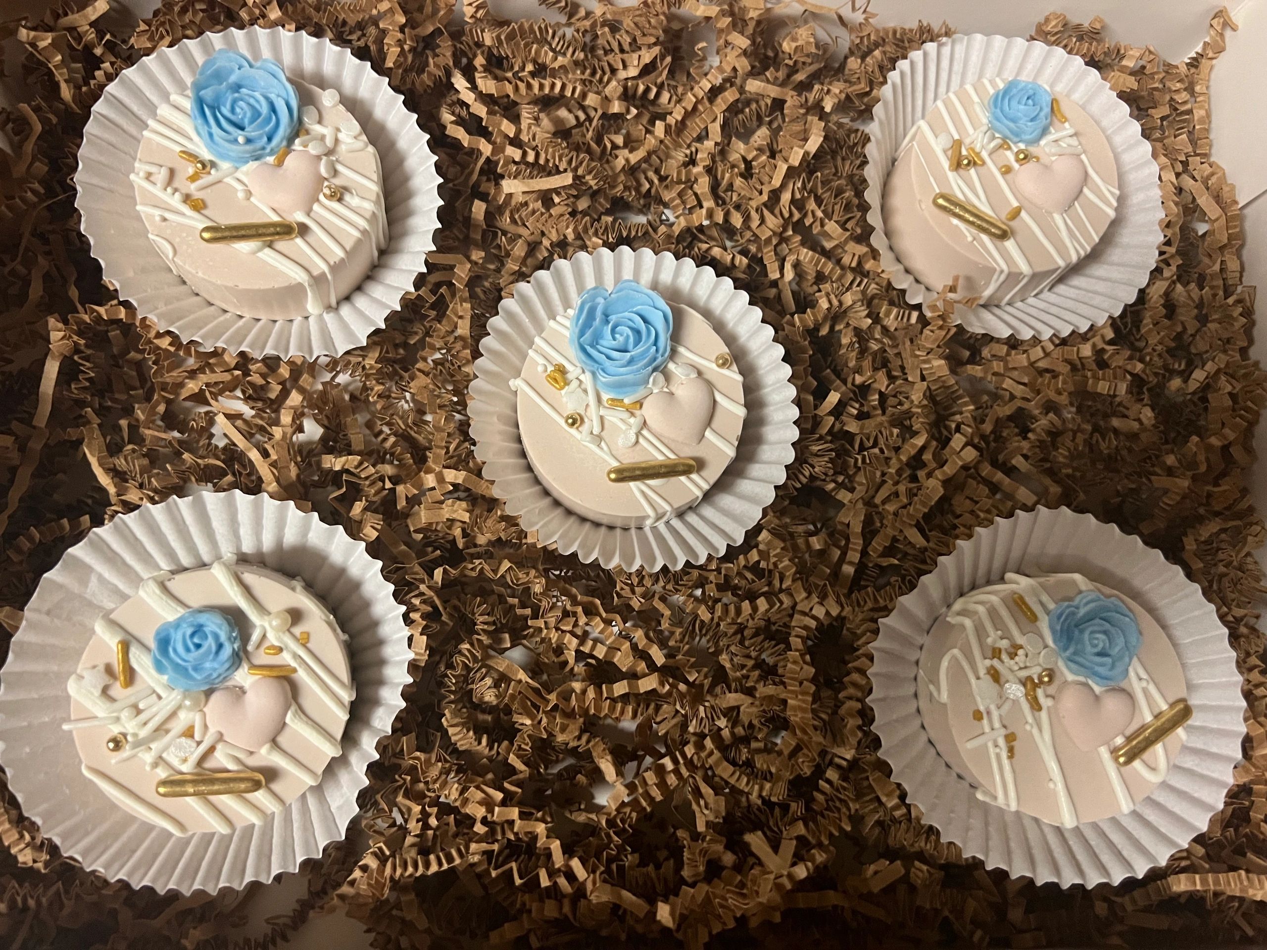 Decorative round treats with blue rose and heart embellishments.