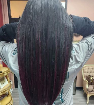 Person with long, straight hair featuring subtle dark purple highlights.