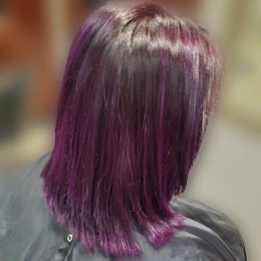 Shoulder-length hair dyed in vibrant purple tones.