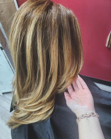 Layered haircut with blonde highlights.
