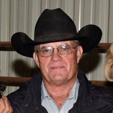 Man wearing a black cowboy hat and glasses.