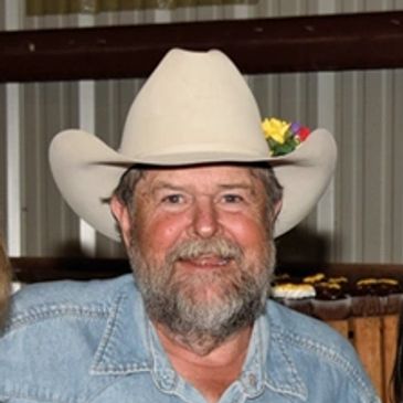 Man wearing a black cowboy hat and glasses.