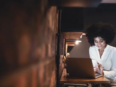 Woman using laptop and smiling.