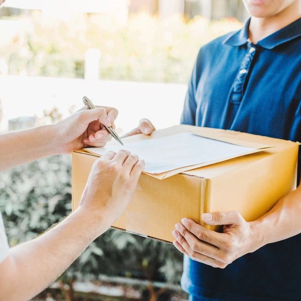 Person unterschreibt Lieferung auf Paket.