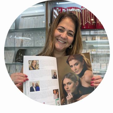 Woman smiling while holding an open magazine with fashion models.