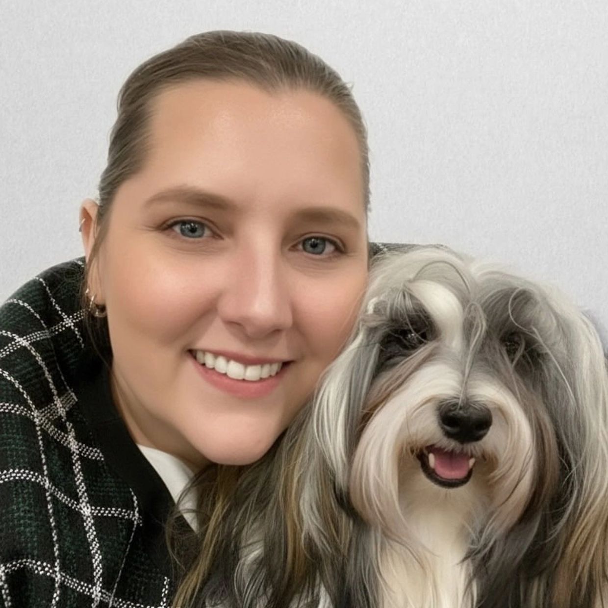 Woman smiling with a fluffy dog.