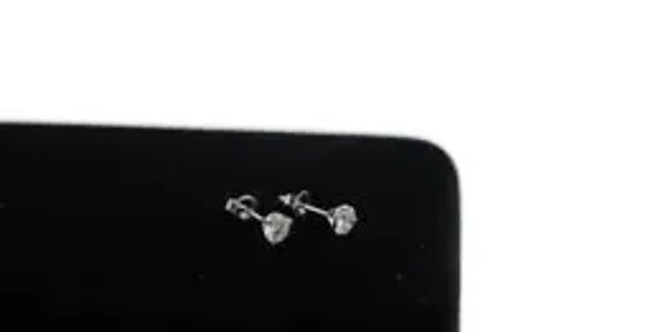 Close-up of a pair of silver stud earrings with clear gemstones.