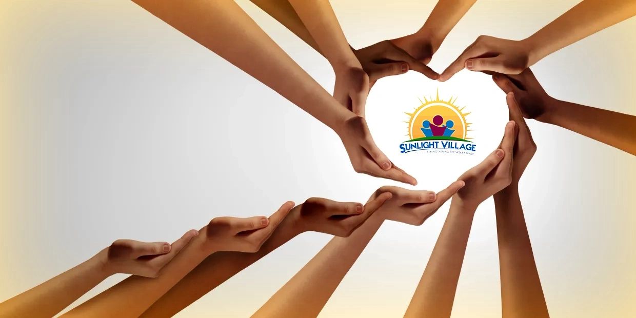 Hands forming a heart shape around Sunlight Village logo.