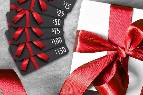Gift cards with red ribbons and a wrapped present.