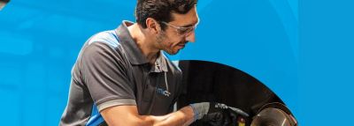 Technician inspecting a mechanical component with tools and gloves.
