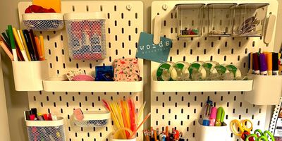 A pegboard containing different containers with office products organized within