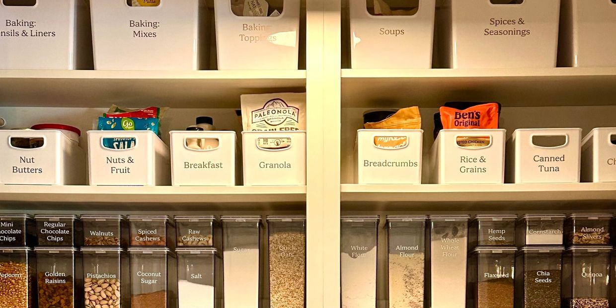 A picture of a pantry with white containers that are labeled and clear containers of dry goods 