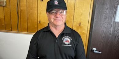 Man wearing black uniform and cap.