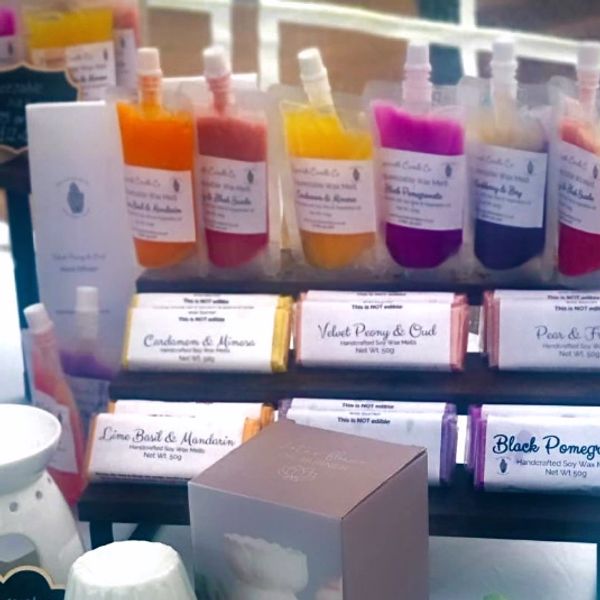 Display of colorful handmade soap products with labels.