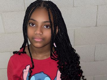 Young girl with long braided hair and a red Stitch shirt.