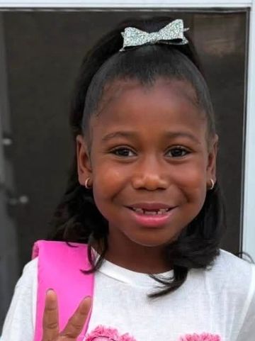 Smiling young girl with a bow in her hair.