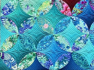Colorful quilt with intricate floral patterns and detailed stitching.