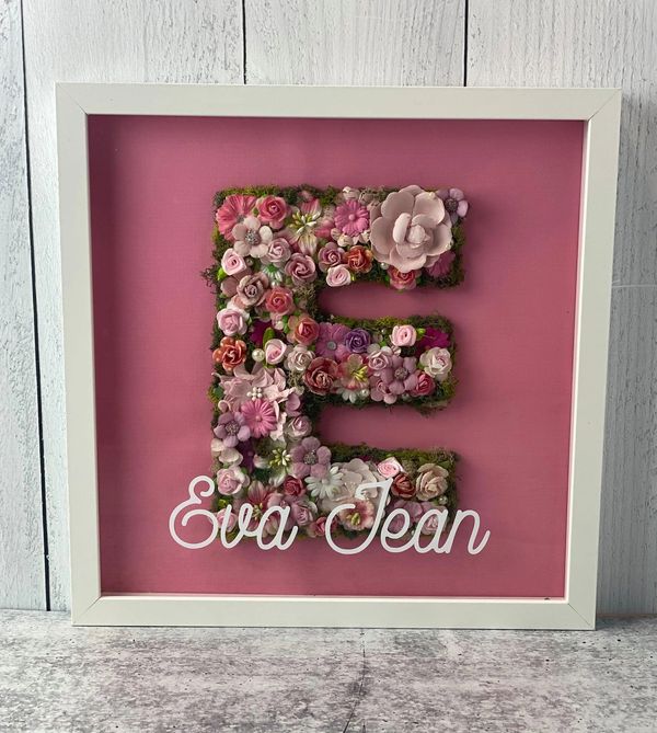 letter E in pink flowers in a white shadowbox frame