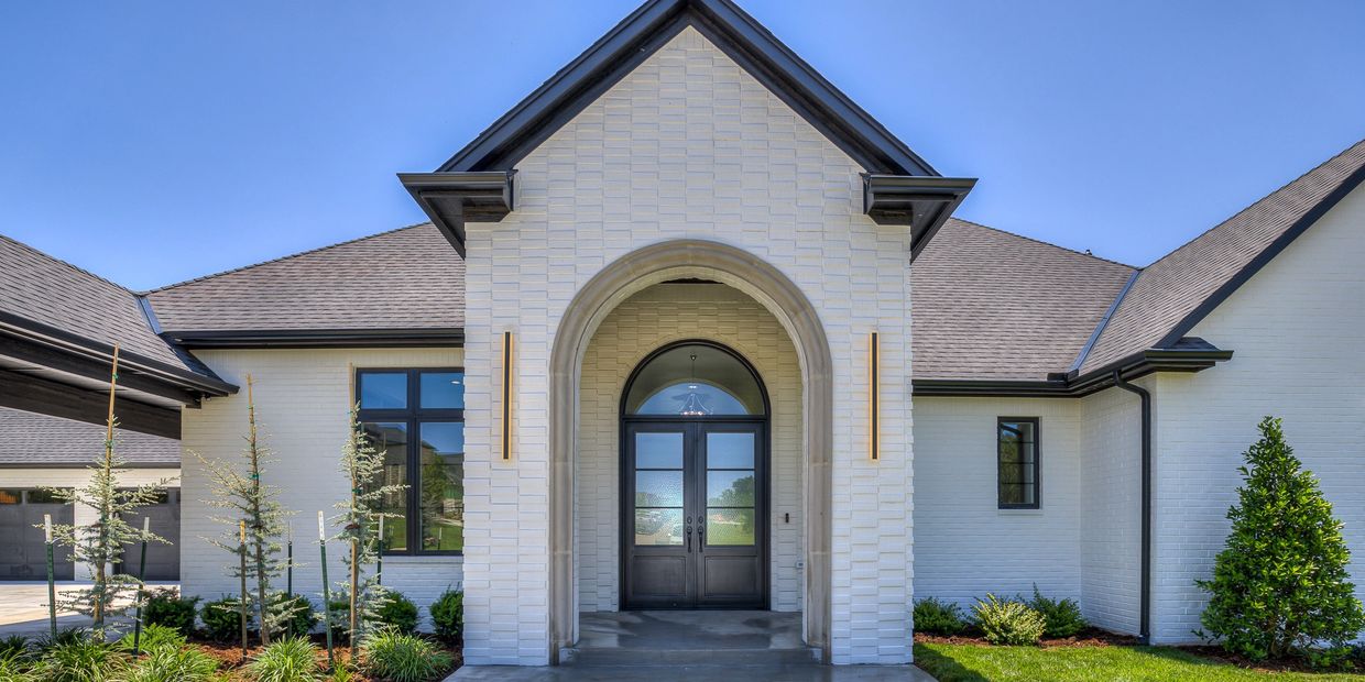 Custom home by Morgan Homes in Edmond - OK, white brick, arched entryway, refined craftsmanship.
