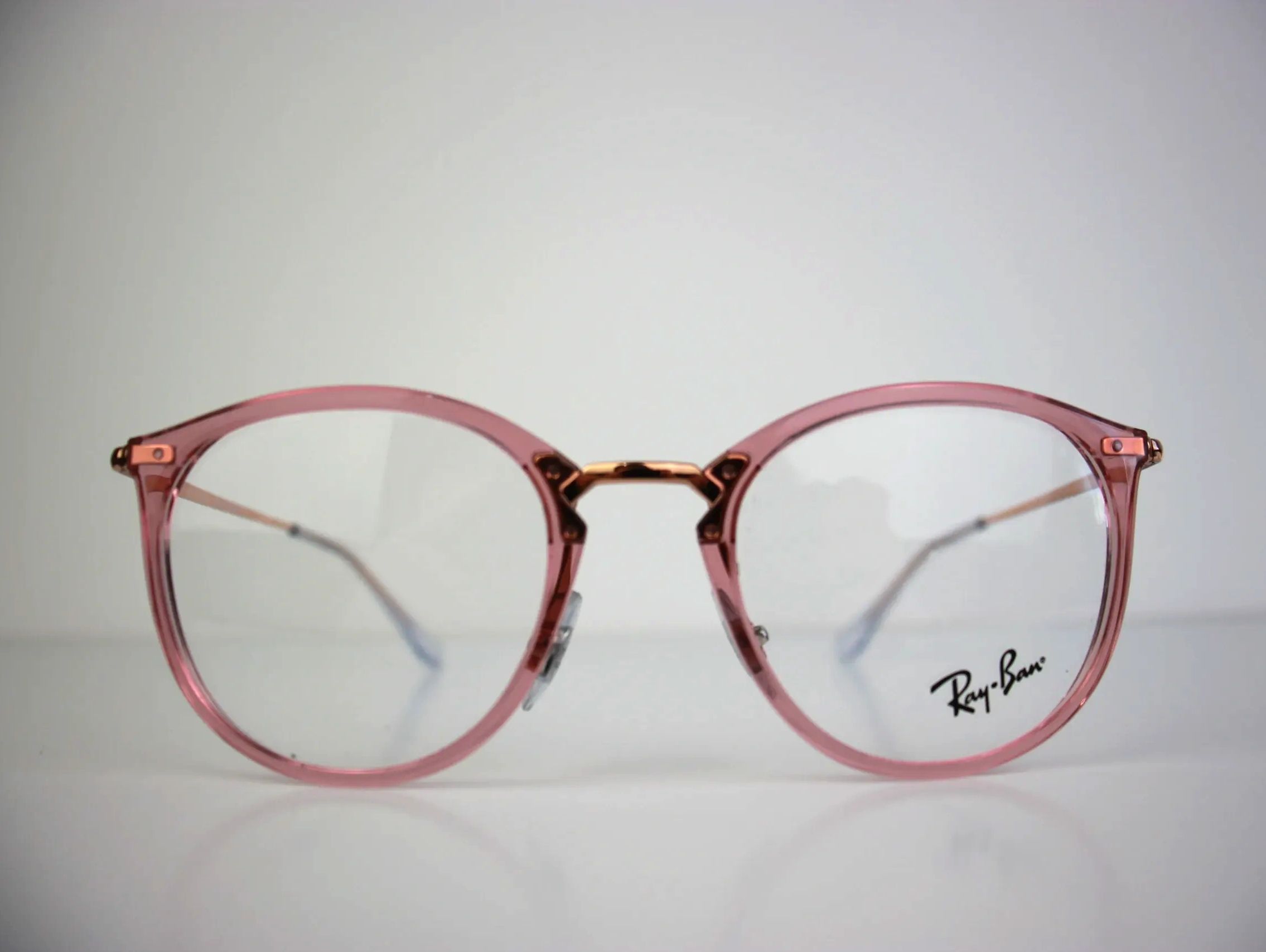 Close-up of pink Ray-Ban eyeglasses with a transparent background.