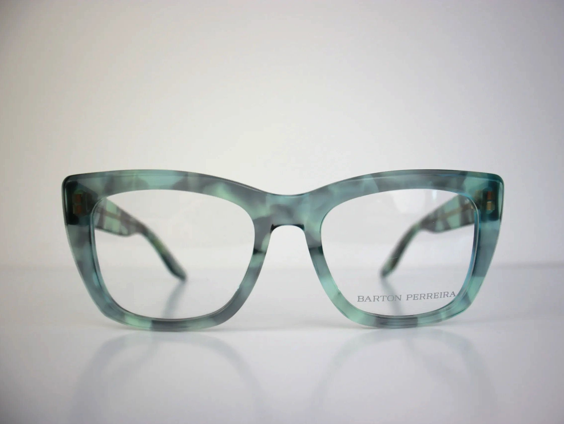 Close-up of stylish blue-green cat-eye eyeglasses by Barton Perreira.