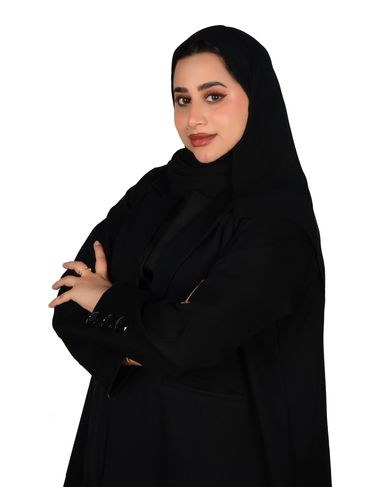 Woman in black abaya and hijab smiling confidently.