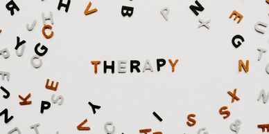 The word 'THERAPY' spelled out with scattered letters around it.