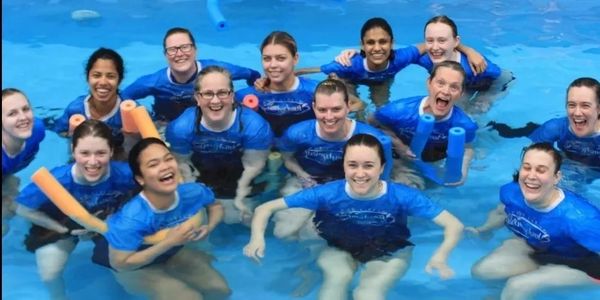 A friendly happy smiling team of Swim Teachers in the pool