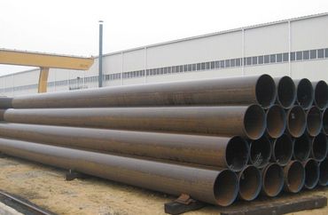 Stack of large industrial steel pipes outdoors.
