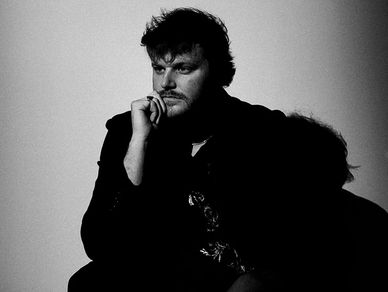 Black and white portrait of a man in deep thought, casting a shadow on the wall.
