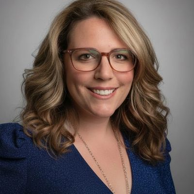 Professional portrait of a smiling woman with blonde hair and glasses.