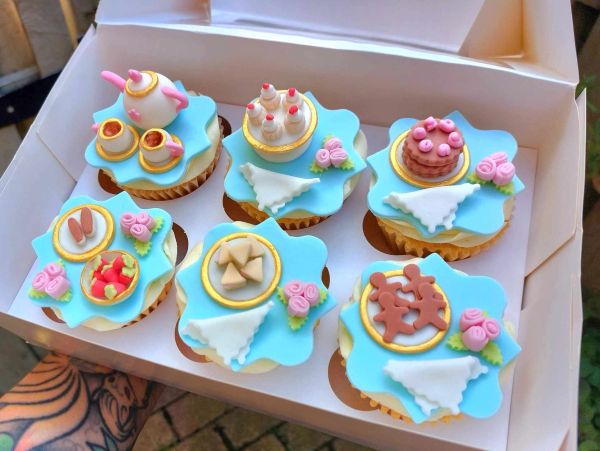 Tea party themed cupcakes with pastel decorations.