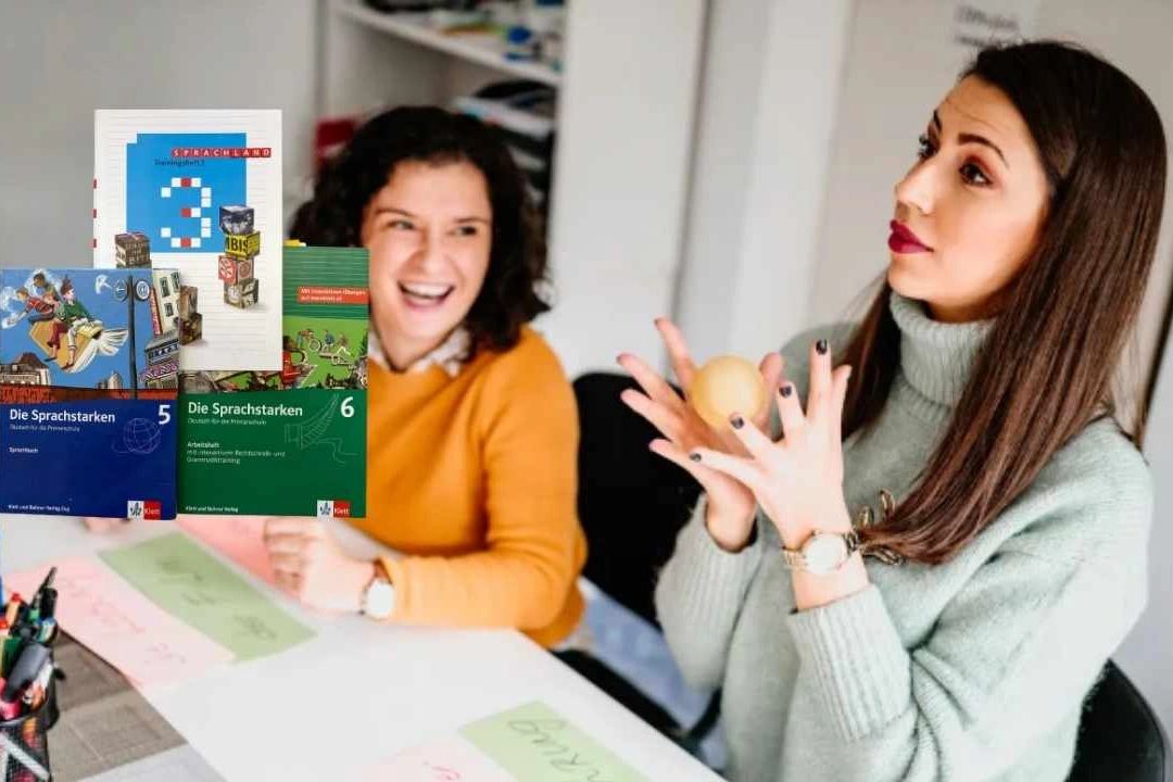 Zwei Frauen lachen und sprechen an einem Tisch mit Sprachbüchern.