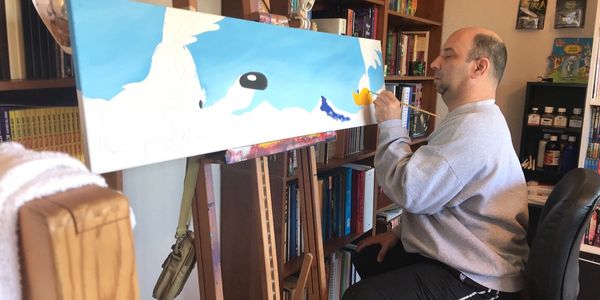 A photo of myself painting the Road Runner and Wile E. Coyote.