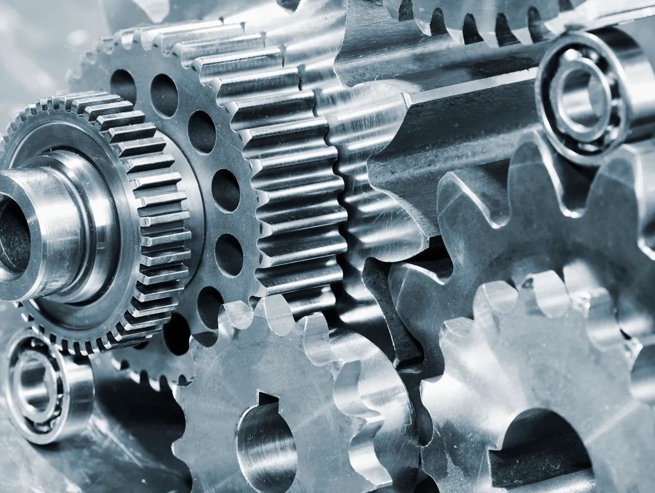 A stack of power transmission components consisting of gears, sprockets, and bearings.
