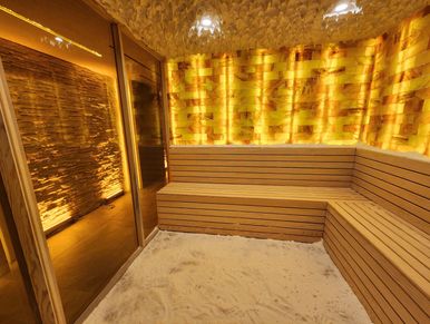 Cozy sauna room with wooden benches and warm lighting.